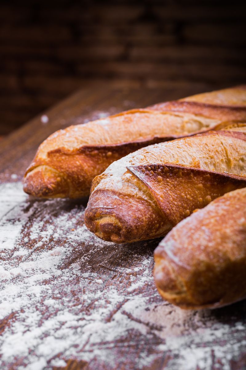Hogaza de pan de masa madre cortada sobre una tabla de madera junto a un cuchillo